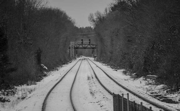 a two long train tracks covered with snow