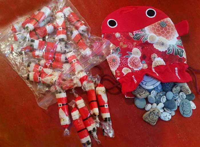 Japanese Santa Crackers (left) , with "lucky Jizo" painted by Kris Kondo, Japan, representing the joining of hearts, those gone and here (Photo - Kathabela Wilson).