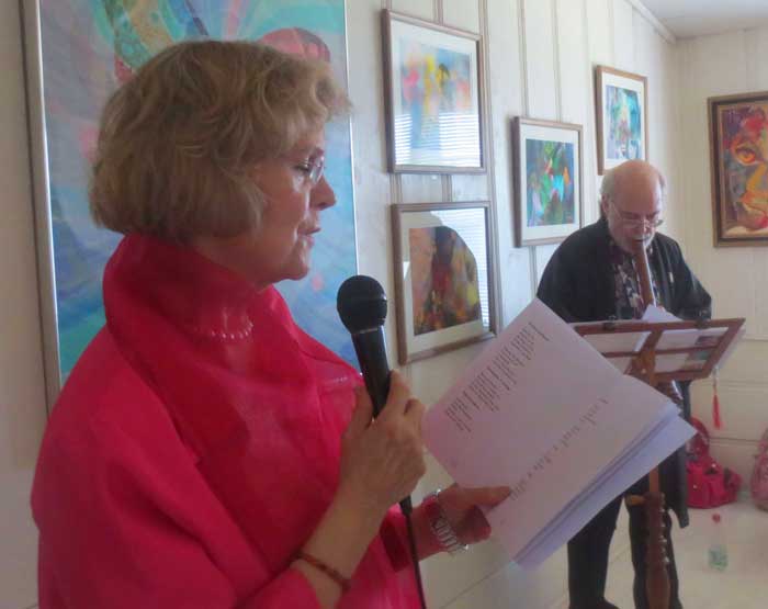 Pauli Dutton reciting her poetry with Rick Wilson playing the flute in the background.