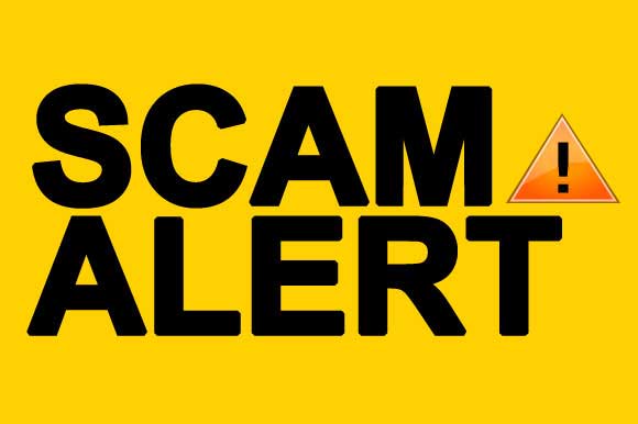 a yellow sign that says scam alert