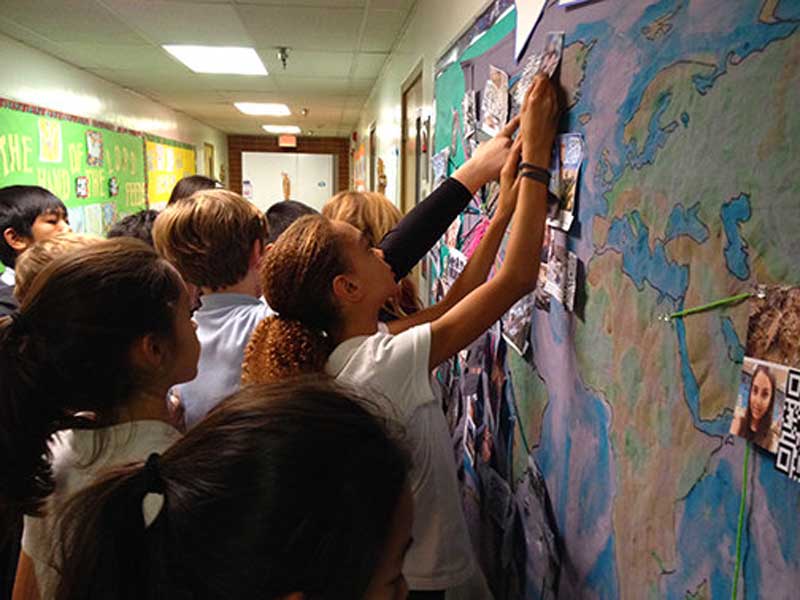 students placing earthquake information on a bulletin board