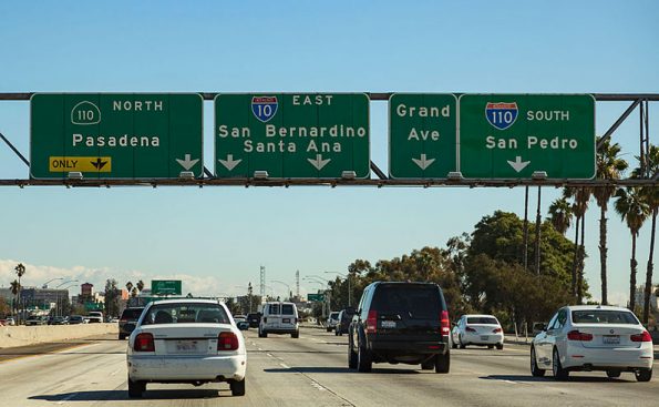 green freeway signs and cars on freeway