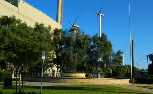 A power plant with adjacent green trees