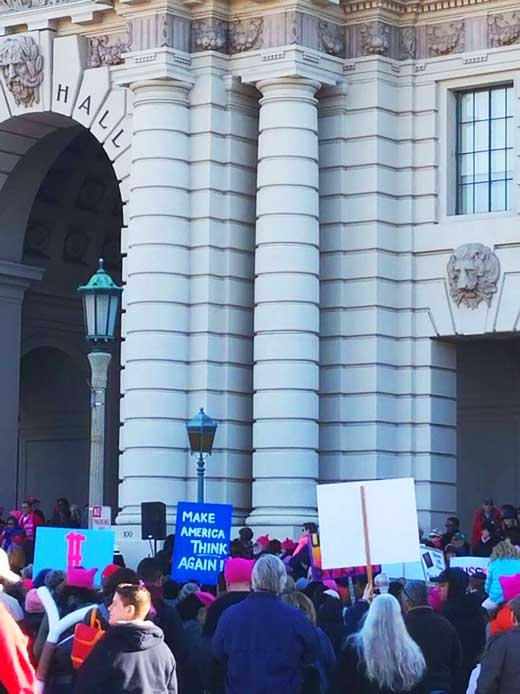 people gathering in front of a building with signs