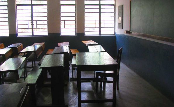 a darkened classroom with desks