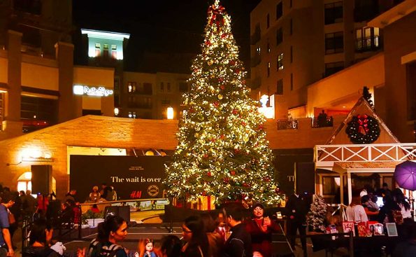 A lighted Christmas tree in the middle of a square