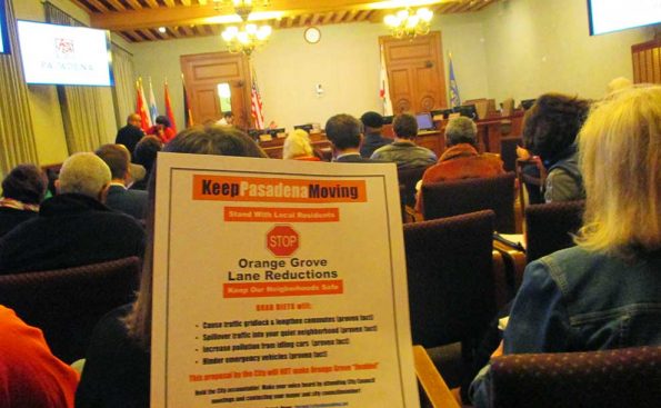 A resident holds a sign regarding the widening of Orange Grove (Photo - Garrett Rowlan)..