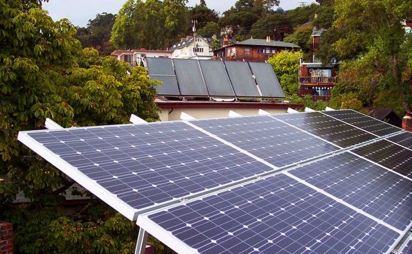 Low tilted photovoltaic panels optimized for summer, and high tilted water heating panels optimized for winter, placed on rooftops in Berkeley, CA (Photo – Firstcultural, Wikipedia).