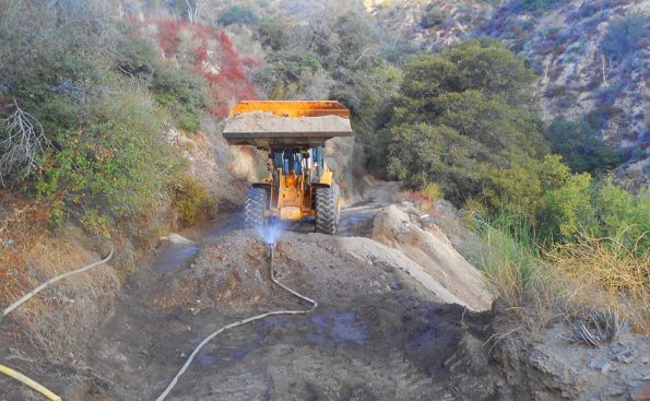 Earthmover bringing soil to fill in ruts (Photo - Reg Green).