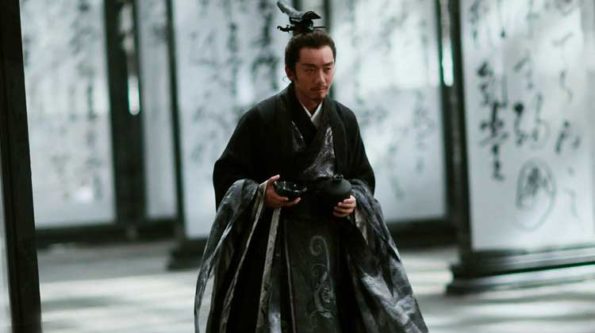 a smauri in a dark shaul with snow behind him