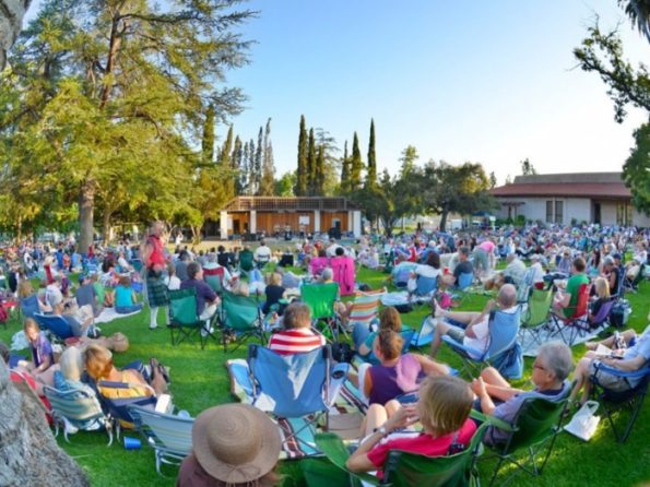 people gatheres on the lawn watching a play