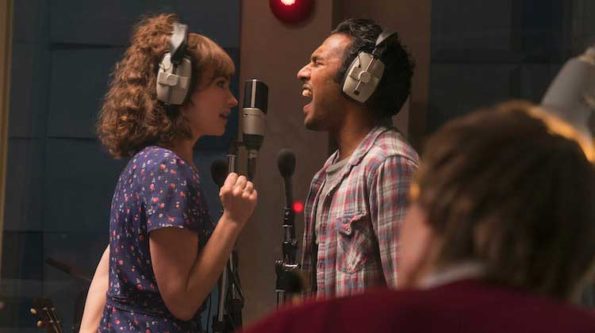 a man and a woman singing in front of a microphone