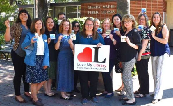 A group of women holding their library card in their hands