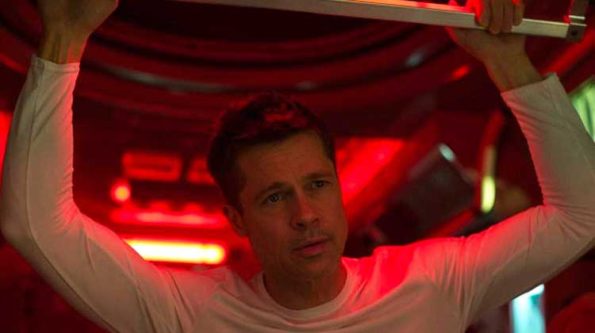 a man in a reddish hue looking off screen