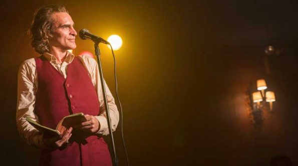 A man in a vest and light begind him