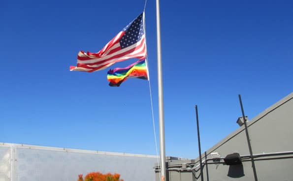 An American flag and a rainbow flg underneath it
