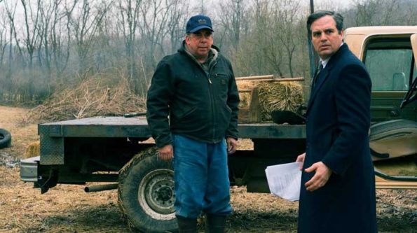 two men, one with a coat and the other in construction clothes talking