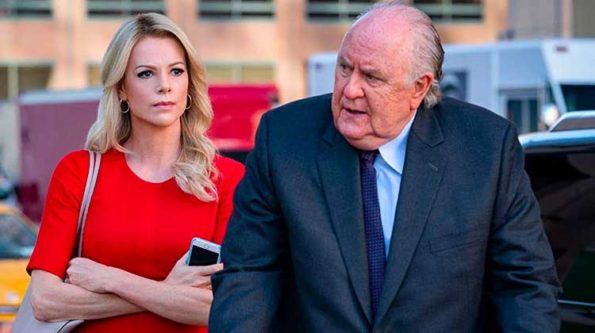 A woman in red dress and an older looking man in navy suit