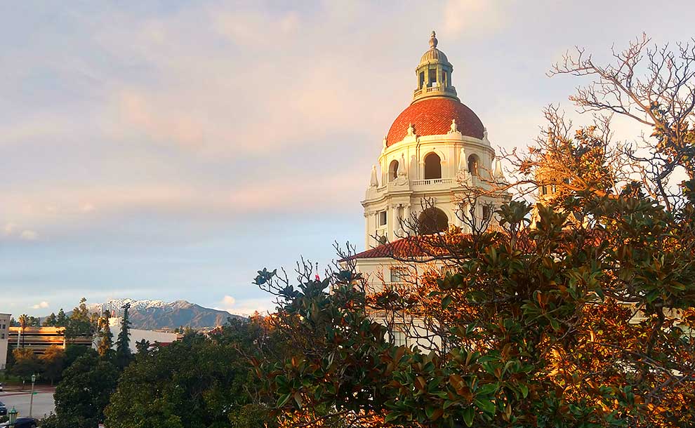 A dome with sun rays on it and snow in the mountains behind it