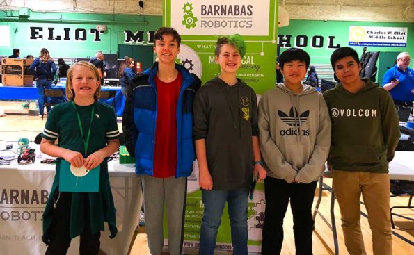 Students stand in front of a Robotic sign