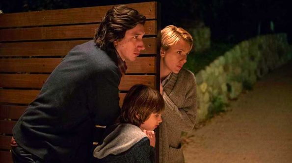 A man and a woman closing a gate with a kid