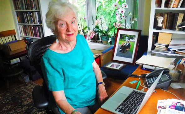 A woman in a blue dress sitting at her desk