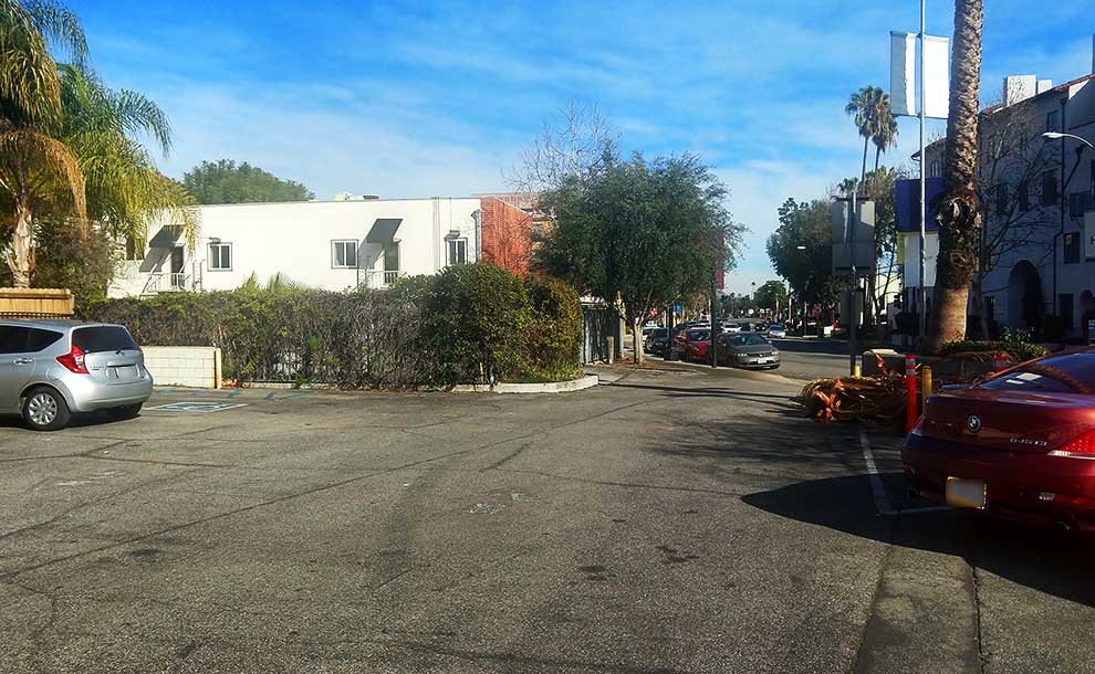 A parking lot with an abandoned building in the background