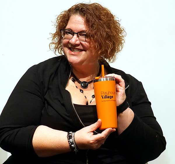 a woman holding a cup in her hands and smiling