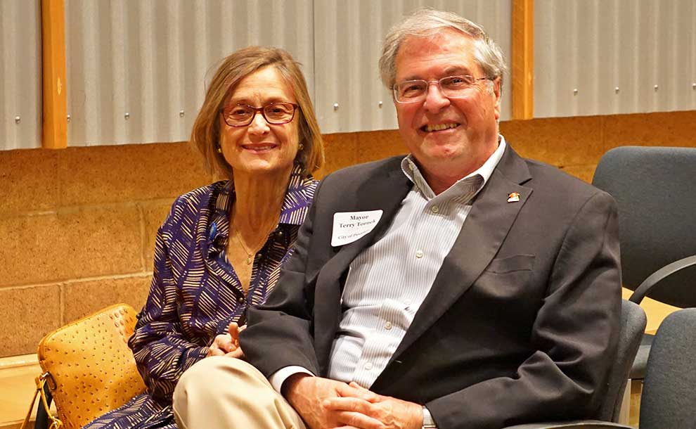 A man and his wife smiling at the camera