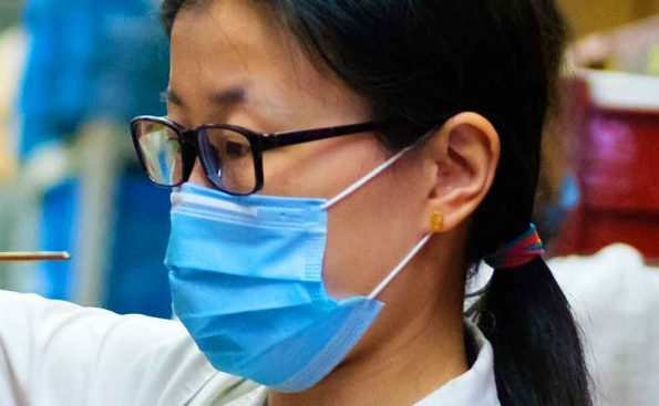 A woman wearing a blue mask and glasses