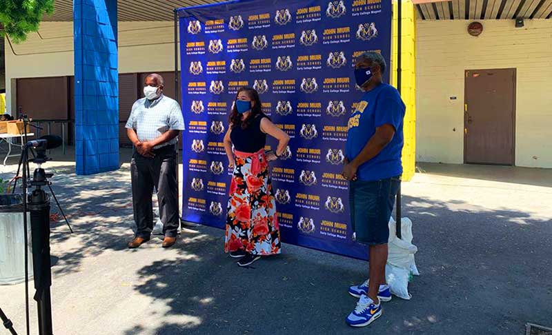 two men and one femal student wearing makss taking their senior prom photos