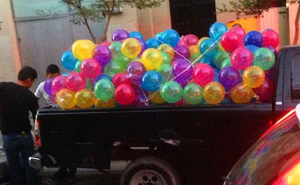 bunch of balloons on tthe bed of a truck