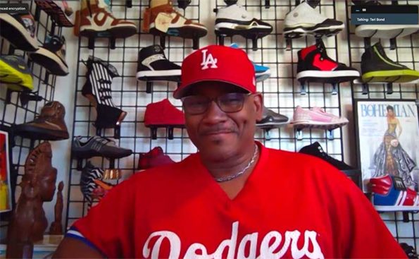 A man with red hat and t-shirt with sneakers behind him
