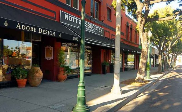 Shops with an old fashioned lamp post and boutiques on a colorful street
