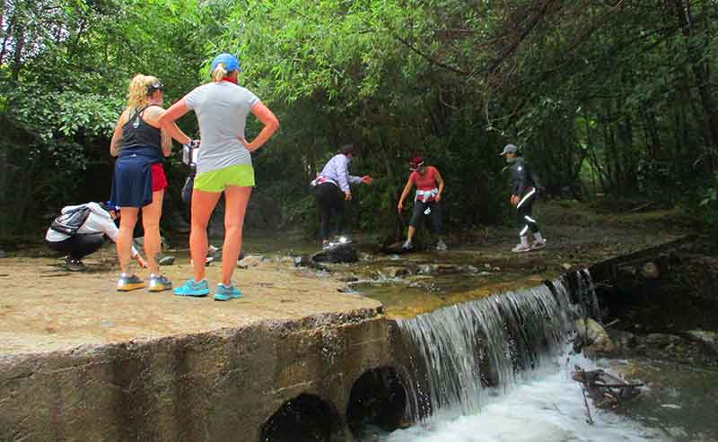 woman and mean try to pass a creek