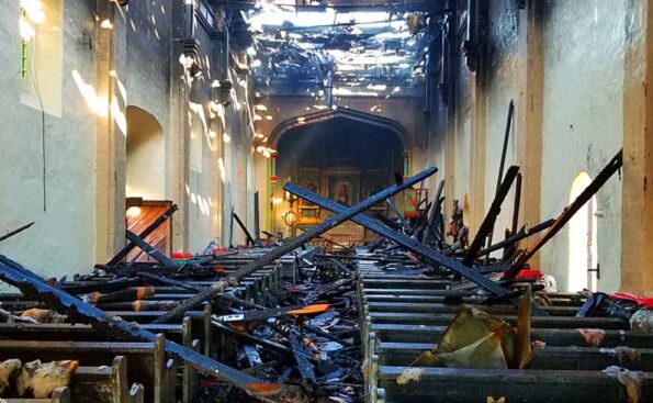 Charred pews and roof with altar intact