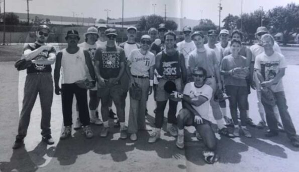 Black and white photo of q group of guys at a softball game