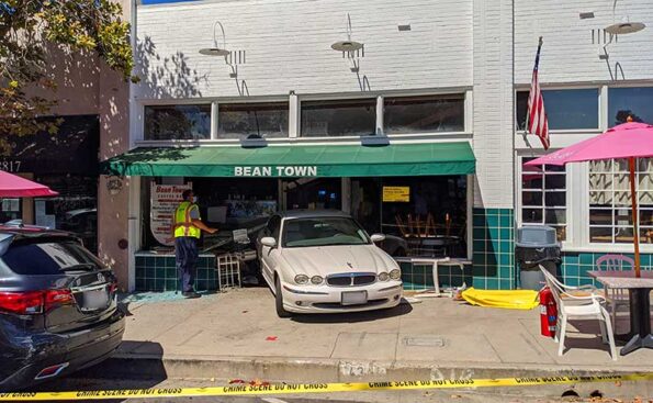 A car sits inside the front window of a shop
