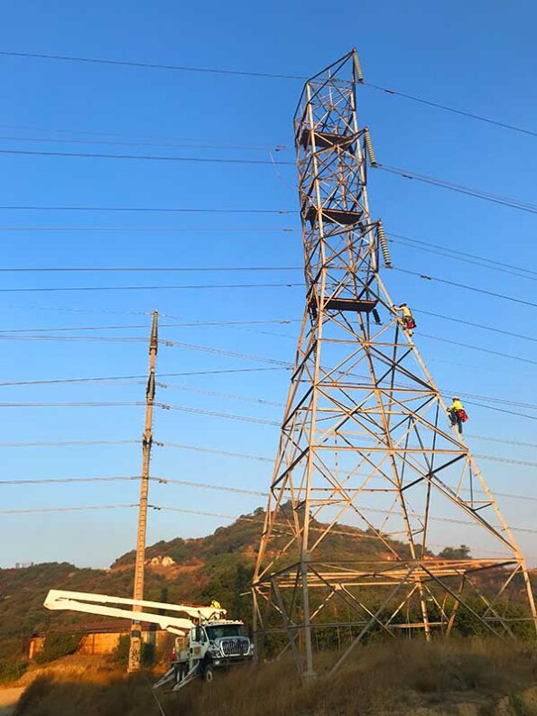 workers climbing a utility power line