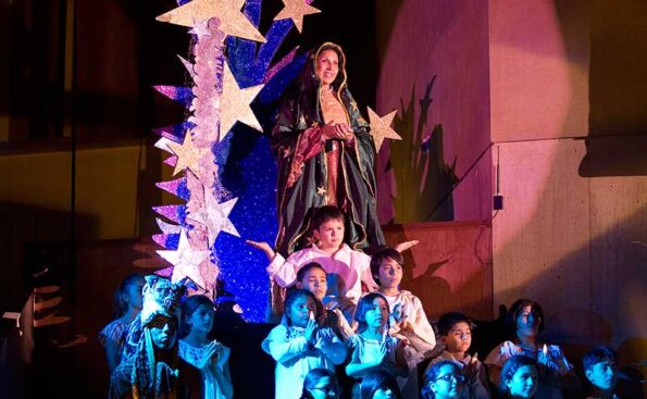 a woman in a blue dress and vail surrounded by children
