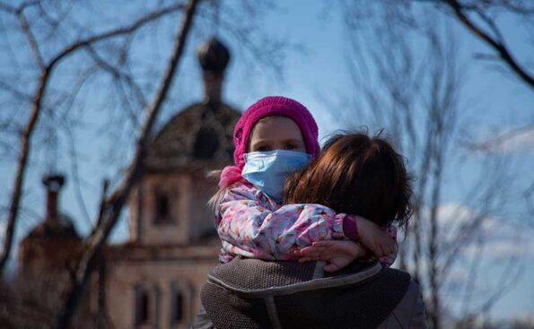 A girl with mask clinging to her mom