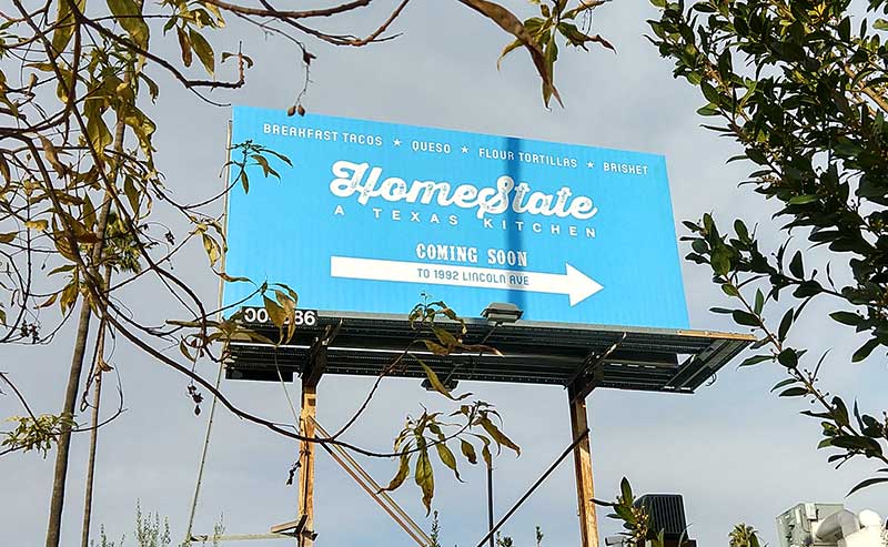 a blue colored billboard and leaves around it