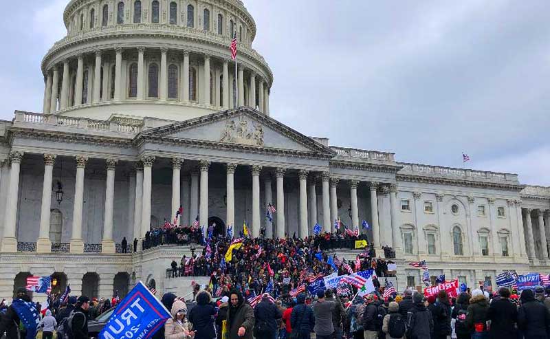 crowd converging on the steps of a large building