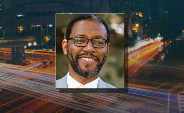 An African American person smiling with glasses