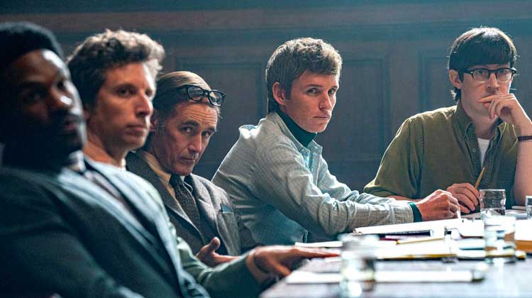 white men on a table looking at a black person