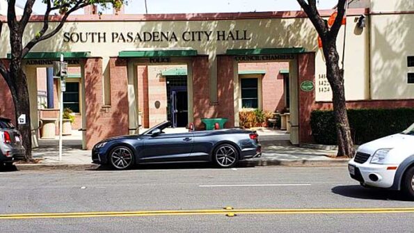 cars parked on the street in front of a building