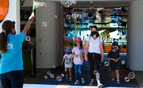 mother and children and an employess showering them with bubbles