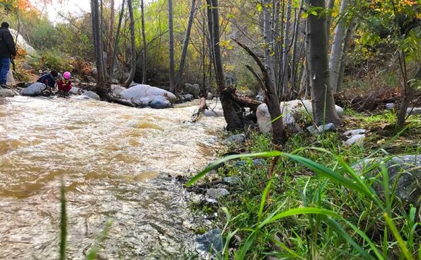 a raging river with kids playing on its banks
