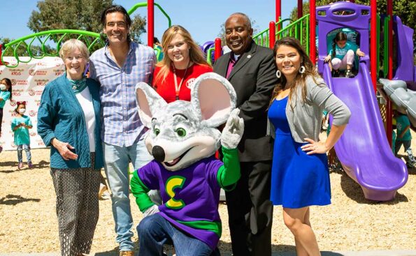 people standing for a photo op with a mouse character up front