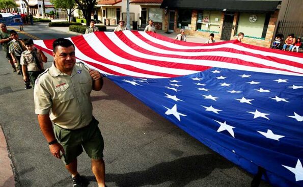 Adults and kids holding a giant flag